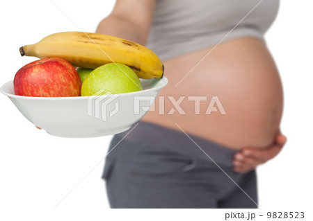 Pregnant woman showing fruit bowl to camera Pregnant woman showing fruit bowl to camera 9828523