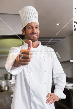 Happy young chef looking at camera showing thumb up 9828792