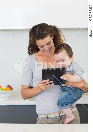Mother and baby using digital tablet 9828880
