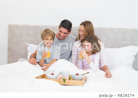 Family having breakfast together in bed 9829274