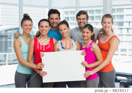 Fit smiling people holding blank board Fit smiling people holding blank board 9829317