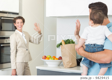 Family waving goodbye to businesswoman 9829415