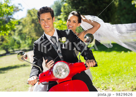 Newlywed couple enjoying scooter ride 9829626