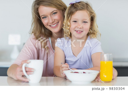 Mother and daughter having breakfast at table Mother and daughter having breakfast at table 9830304