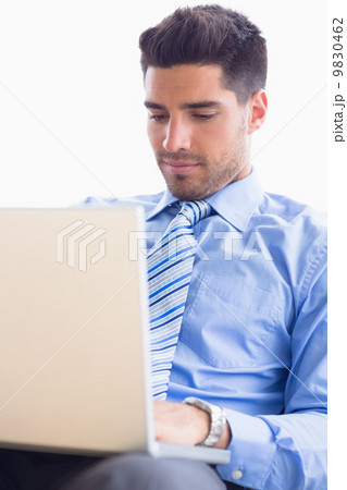 Businessman on couch using his laptop Businessman on couch using his laptop 9830462