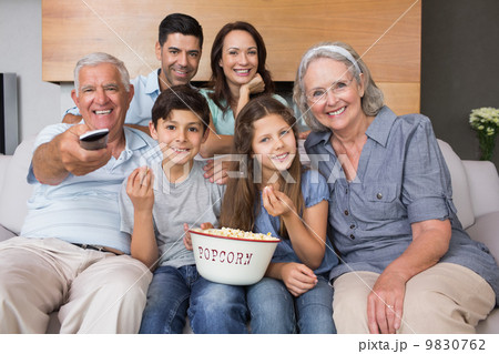 Portrait of happy extended family watching tv in living room Portrait of happy extended family watching tv in living room 9830762