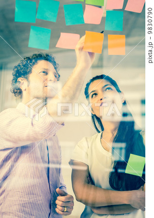 Business people discussing over adhesive notes Business people discussing over adhesive notes 9830790