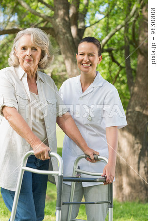 Female assisting mature woman with walker at park Female assisting mature woman with walker at park 9830808