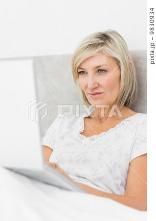 Mature woman using laptop in bed Mature woman using laptop in bed 9830934