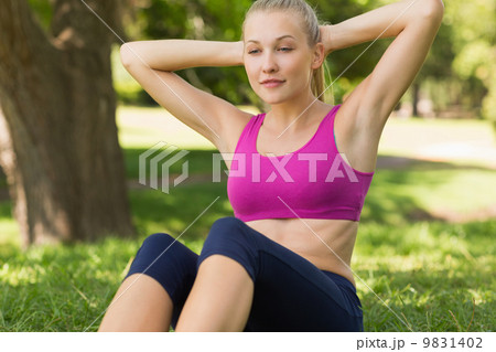 Healthy and beautiful woman doing stomach crunches in park Healthy and beautiful woman doing stomach crunches in park 9831402