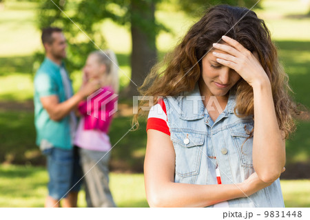 Angry woman with man and girlfriend in background at park 9831448