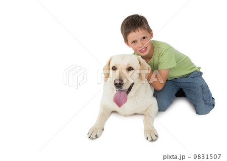 Cute little boy kneeling with his labrador smiling at camera 9831507