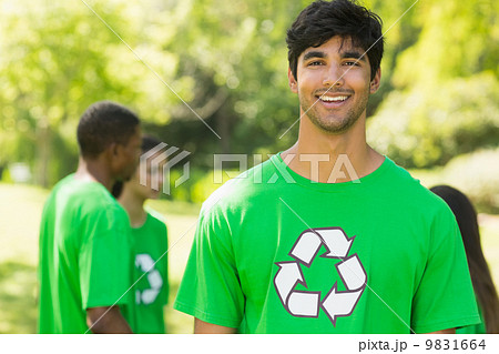 Smiling man wearing green recycling t-shirt in park Smiling man wearing green recycling t-shirt in park 9831664