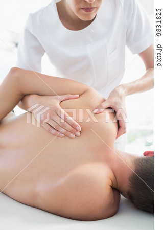 Professional therapist giving shoulder massage to man Professional therapist giving shoulder massage to man 9831825