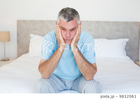 Sad senior man sitting on bed 9832061