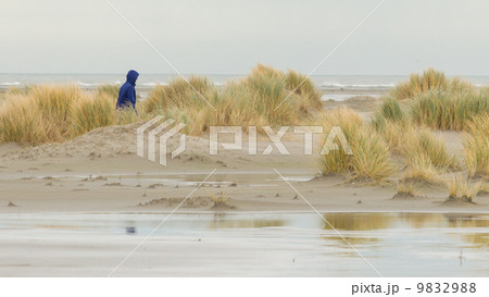 Lonely woman walking on a beach 9832988