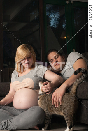 Pregnant couple s petting the cat 9836035