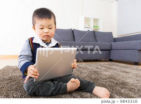 Asian little boy using tablet at home 9843310
