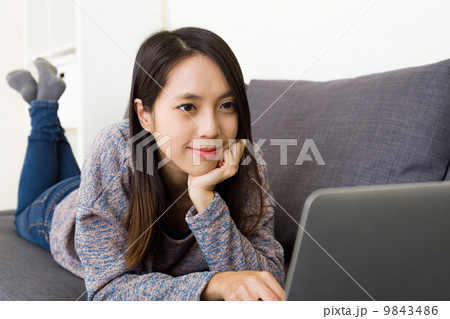 Asian woman watching movie on laptop 9843486
