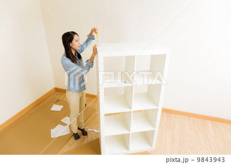 Asian woman assemble a white bookshelf 9843943