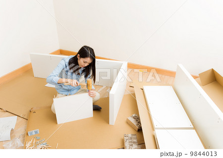 Asian woman assembling closet 9844013