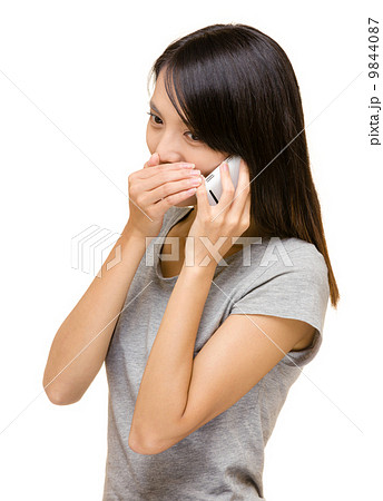 Asian woman talking secret on phone Asian woman talking secret on phone 9844087