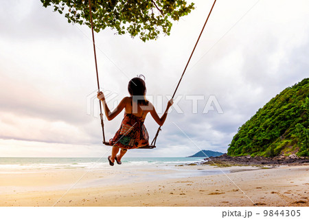 Girl playing the swing on beach 9844305