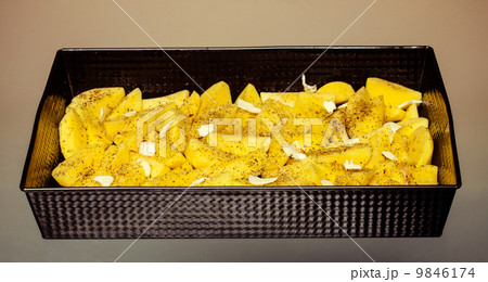 Raw peeled potatoes with spices and butter in tray. Food. Raw peeled potatoes with spices and butter in tray. Food. 9846174