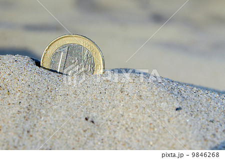 Euro coin in the sand 9846268