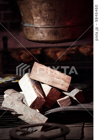 Old hearth with pile of fire wood and pot. Indoor. 9846460