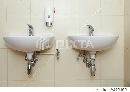 Two white sinks and taps in public toilet 9846466