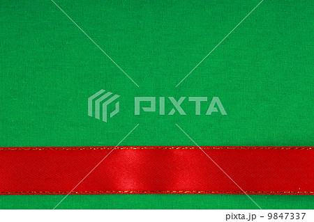 red ribbon on green fabric background with copy space. 9847337