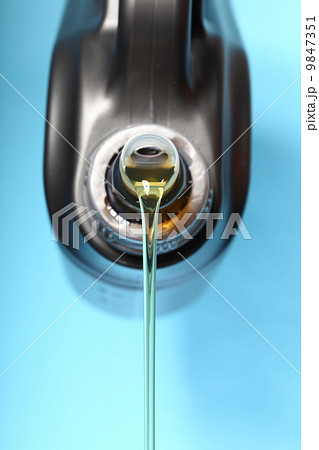 Can with car engine oil pouring blue background 9847351
