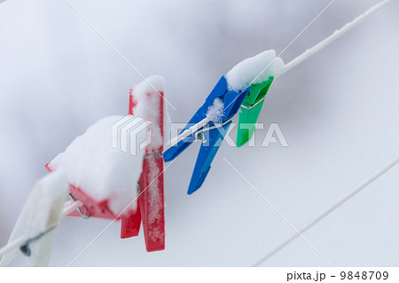 Colorful clips washing laundry covered snow strip rope outdoor. Winter. Colorful clips washing laundry covered snow strip rope outdoor. Winter. 9848709