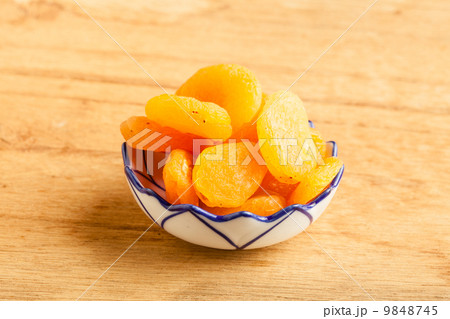 Bowl of dried apricots on wooden table background. 9848745