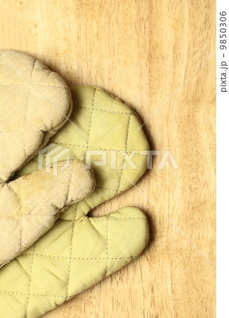 Old wooden kitchen board with protective oven glove Old wooden kitchen board with protective oven glove 9850306