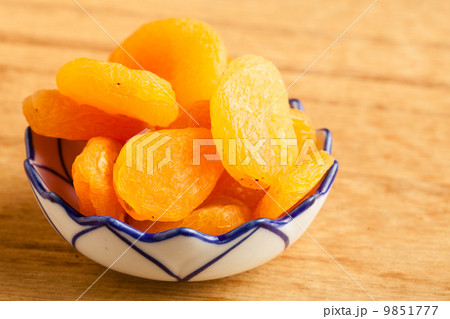 Bowl of dried apricots on wooden table background. 9851777