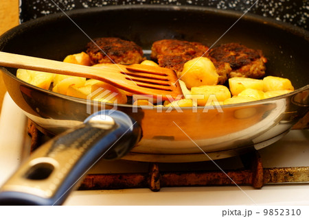Seasoned potato slices in skillet pan in kitchen 9852310