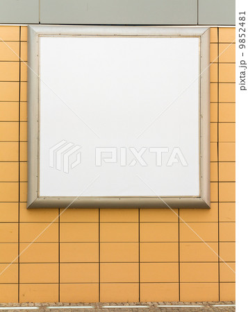 Empty blank square white advertising billboard on orange tiled wall 9852481