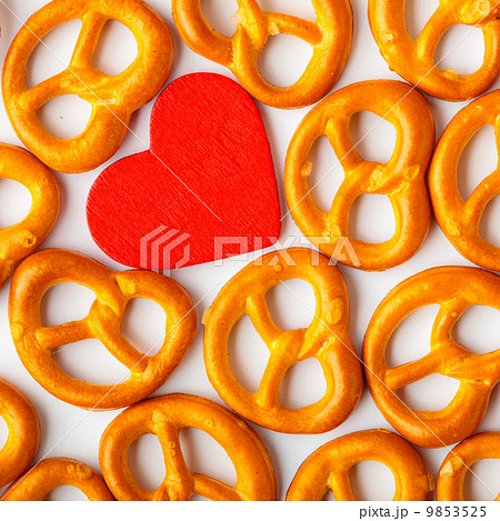 Valentine's day background pretzels pattern and red heart. Valentine's day background pretzels pattern and red heart. 9853525