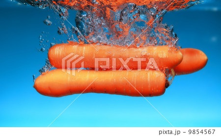 Carrot in the water splash over blue Carrot in the water splash over blue 9854567