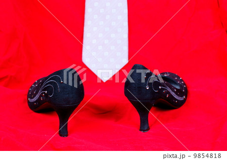 Black female shoes and necktie on red background Black female shoes and necktie on red background 9854818
