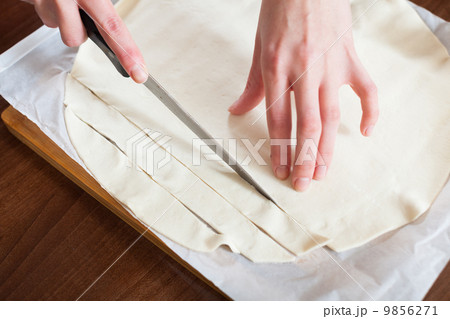 hands cutting store-bought dough 9856271