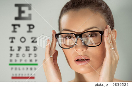 Beautiful young woman wearing glasses standing in front of eye t Beautiful young woman wearing glasses standing in front of eye t 9856522