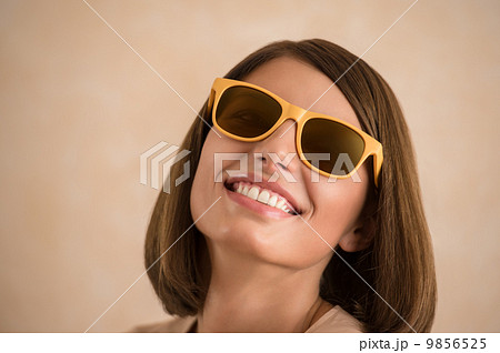 Portrait of beautiful smiling young woman wearing sunglasses 9856525