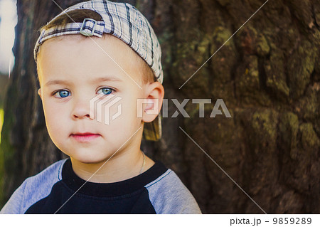 Happy child wearing striped cap in outdoor portrait 9859289