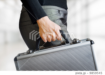 Business woman holding an aluminium briefcase Business woman holding an aluminium briefcase 9859545