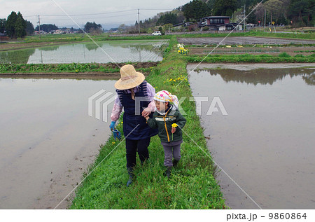 畦道を歩く祖母と孫 9860864