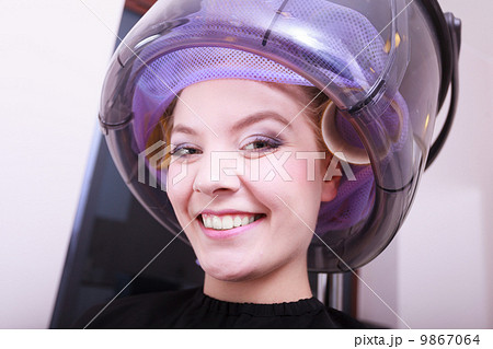 Smiling woman hair rollers curlers hairdryer hairdressing beauty salon 9867064