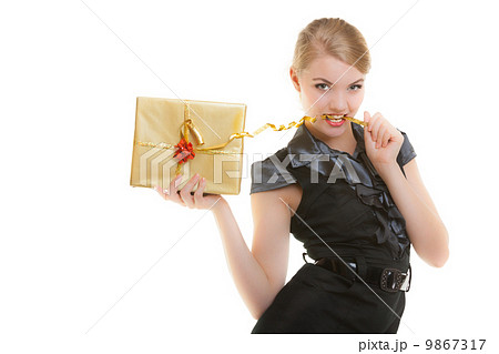 Blond girl with golden christmas gift box ribbon in teeth. Holiday. 9867317